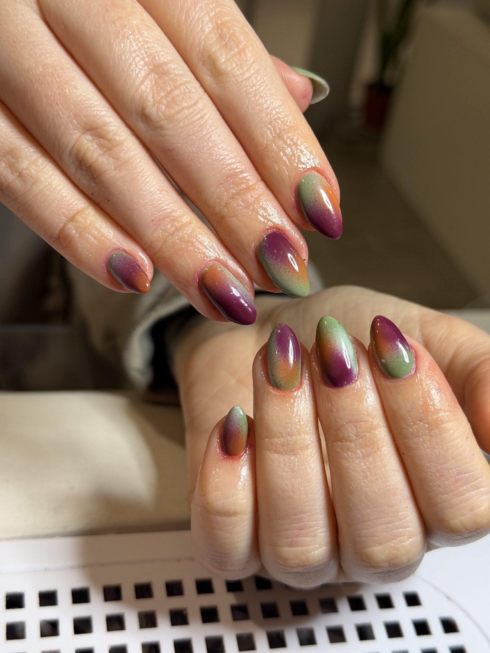 Uñas con efecto magnético multicolor en tonos verdes, violetas y cálidos