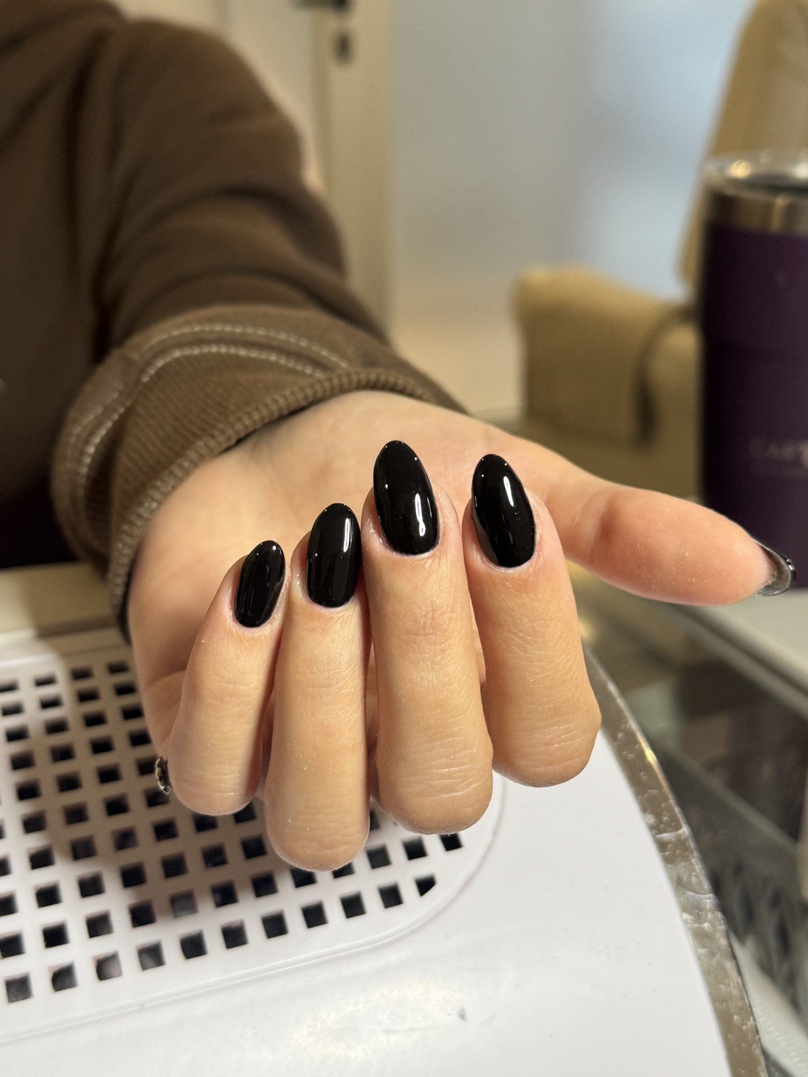 Manicuría en uñas almendradas con esmalte negro brillante